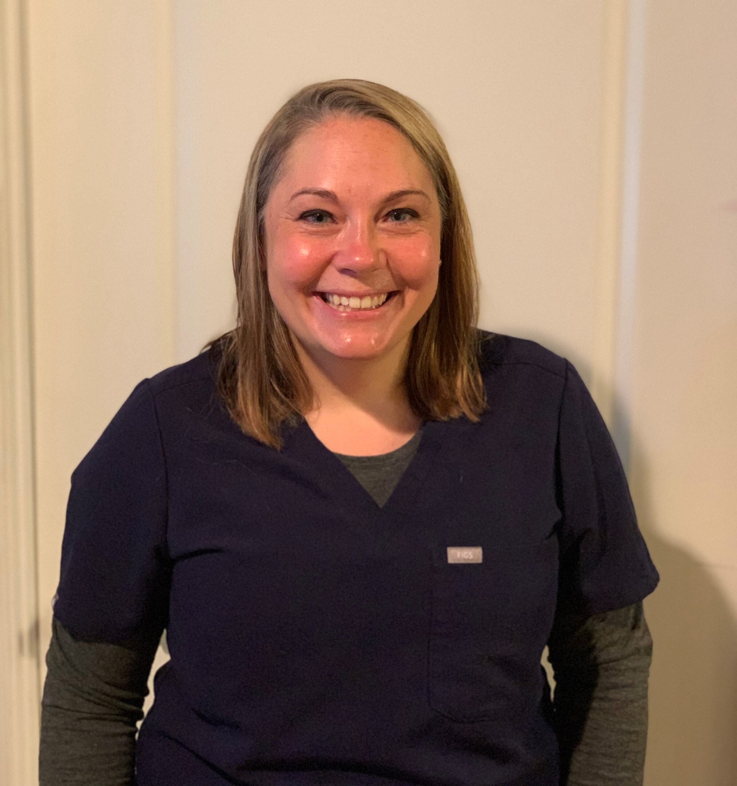 Woman in scrubs smiling