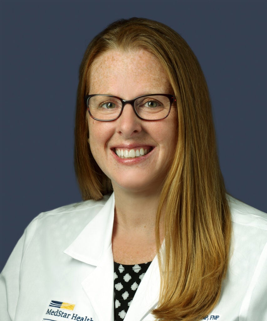 Woman in white coat smiling